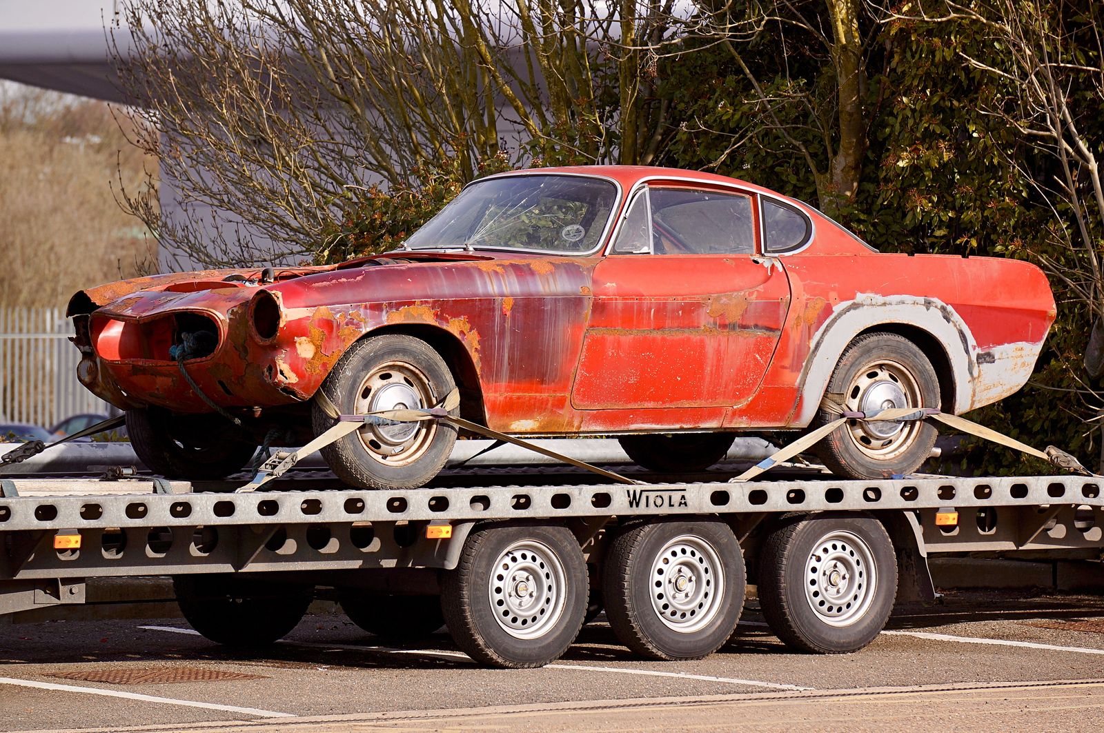 Worn vehicle secured on a flatbed trailer